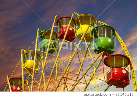 Attraction (carousel) ferris wheel against the background of a romantic evening sky Attraction (carousel) ferris wheel against the background of a romantic evening sky 95145115