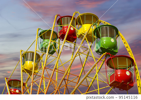 Attraction (carousel) ferris wheel against the background of a romantic evening sky Attraction (carousel) ferris wheel against the background of a romantic evening sky 95145116