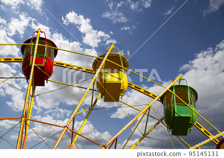 Attraction (carousel) ferris wheel on the background of the cloudy sky 95145131