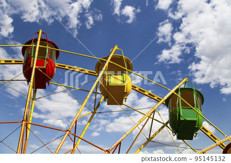 Attraction (carousel) ferris wheel on the background of the cloudy sky 95145132