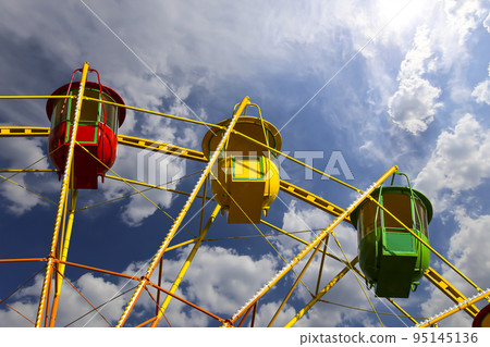 Attraction (carousel) ferris wheel on the background of the cloudy sky 95145136