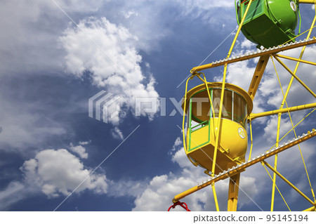 Attraction (carousel) ferris wheel on the background of the cloudy sky 95145194