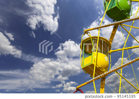Attraction (carousel) ferris wheel on the background of the cloudy sky 95145195