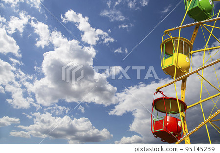Attraction (carousel) ferris wheel on the background of the cloudy sky Attraction (carousel) ferris wheel on the background of the cloudy sky 95145239