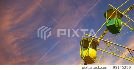 Attraction (carousel) ferris wheel against the background of a romantic evening sky Attraction (carousel) ferris wheel against the background of a romantic evening sky 95145299
