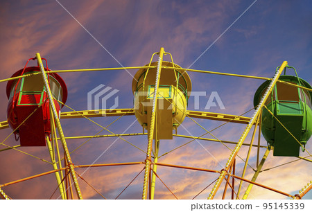 Attraction (carousel) ferris wheel against the background of a romantic evening sky Attraction (carousel) ferris wheel against the background of a romantic evening sky 95145339