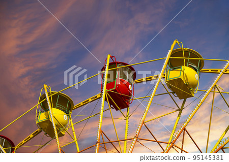 Attraction (carousel) ferris wheel against the background of a romantic evening sky 95145381