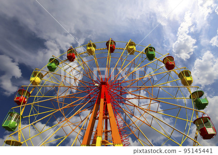 Attraction (carousel) ferris wheel on the background of the cloudy sky 95145441