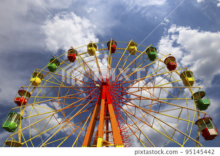 Attraction (carousel) ferris wheel on the background of the cloudy sky Attraction (carousel) ferris wheel on the background of the cloudy sky 95145442