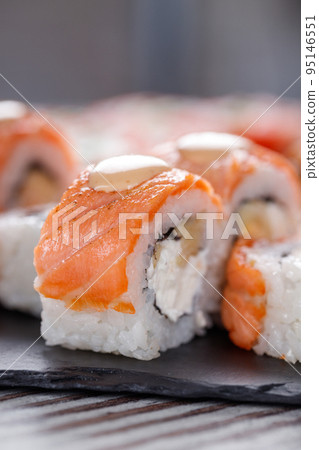 Set of Philadelphia sushi on black concrete plate on table. 95146551