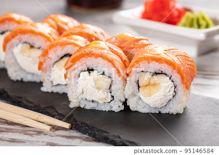 Set of Philadelphia sushi on black concrete plate on table. 95146584