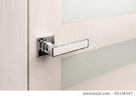 Close up of beautiful and stylish new metal door knob on modern interior door. Close up of beautiful and stylish new metal door knob on modern interior door. 95146587
