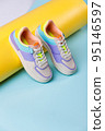 Close up of trendy colored sneakers for teenage girls on colorful yellow-blue background. 95146597