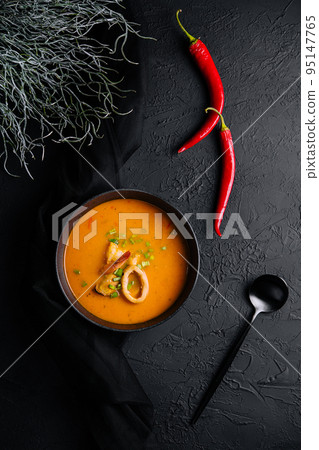 Tom yam seafood soup from above on black stone Tom yam seafood soup from above on black stone 95147765