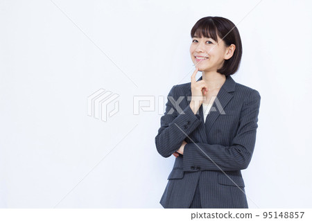 A business woman in her thirties thinking with a smile A business woman in her thirties thinking with a smile 95148857