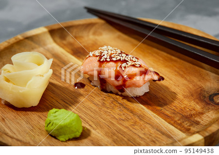 Sushi with smoked eel and sesame seeds on a black background. Japanese dish Unagi sushi. Sushi with smoked eel and sesame seeds on a black background. Japanese dish Unagi sushi. 95149438