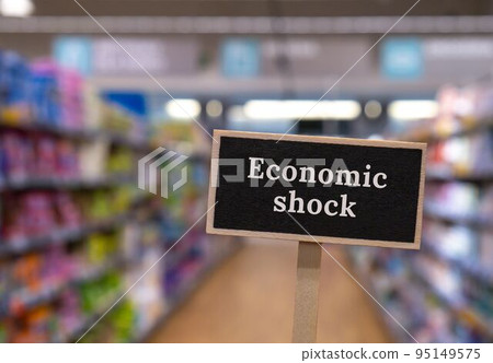 Wooden information label sign with text ECONOMIC SHOCK against defocused store shelves message. Global hunger, inflation, high prices, increasing living expenses and poverty, financial crisis, food 95149575