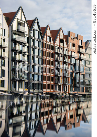 Modern buildings on Granary Island over the Motlawa River in Old Town. Abstract structure. Creative photo Tourism on the Motlawa River. New Apartments architecture glass windows with reflections 95149619