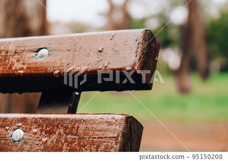 Wet bench in the park in the rain. Rainy weather. Wooden chair in the rain. Wet urban furniture. Rain drops on wooden bench. Wet bench in the park in the rain. Rainy weather. Wooden chair in the rain. Wet urban furniture. Rain drops on wooden bench. 95150208