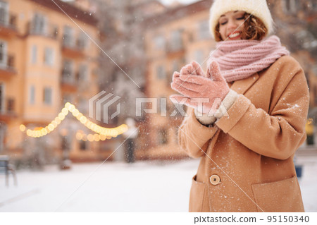 Young woman in winter style clothes posing at festive street market. Cold weather. Winter fashion, holidays. Young woman in winter style clothes posing at festive street market. Cold weather. Winter fashion, holidays. 95150340