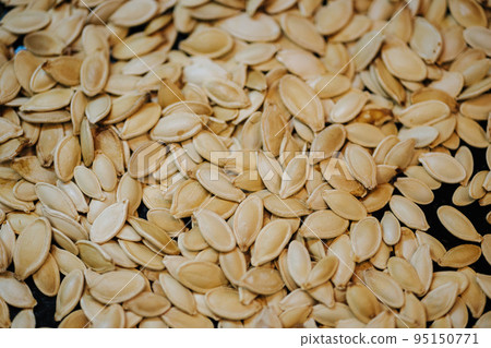 Scattered across the baking sheet roasted pumpkin seeds in shell Scattered across the baking sheet roasted pumpkin seeds in shell 95150771