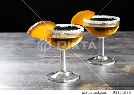 Sidecar cocktail with a sugar rim on wooden table 95151689