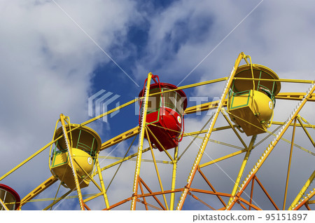 Attraction (carousel) ferris wheel on the background of the cloudy sky Attraction (carousel) ferris wheel on the background of the cloudy sky 95151897