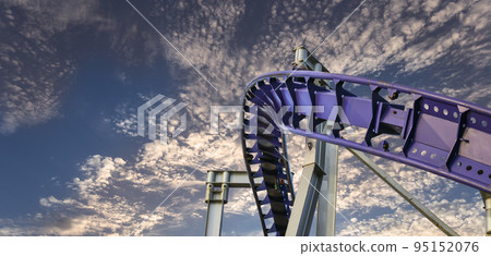 Attraction roller-coaster (switchback) against the background of a romantic evening sky 95152076