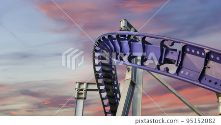 Attraction roller-coaster (switchback) against the background of a romantic evening sky Attraction roller-coaster (switchback) against the background of a romantic evening sky 95152082