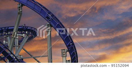 Attraction roller-coaster (switchback) against the background of a romantic evening sky Attraction roller-coaster (switchback) against the background of a romantic evening sky 95152094