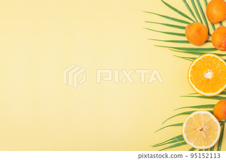Bright tropical background with palm leaves and fruits Bright tropical background with palm leaves and fruits 95152113