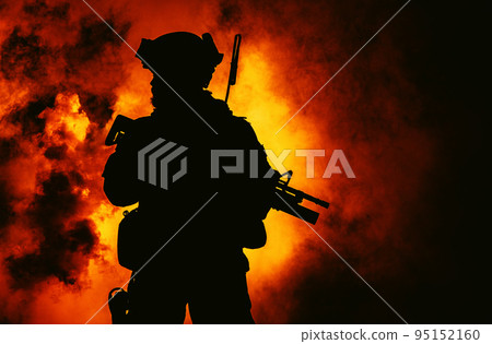 Silhouette of modern infantry soldier, elite army fighter in tactical ammunition and helmet, standing with assault service rifle in hands in the fire and smoke Silhouette of modern infantry soldier, elite army fighter in tactical ammunition and helmet, standing with assault service rifle in hands in the fire and smoke 95152160