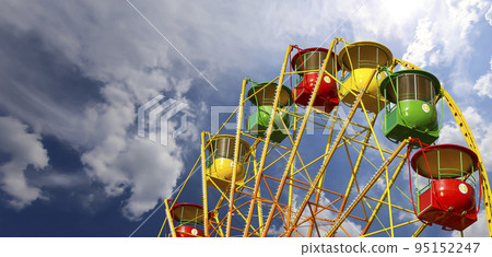 Attraction (carousel) ferris wheel on the background of the cloudy sky Attraction (carousel) ferris wheel on the background of the cloudy sky 95152247