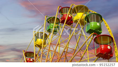 Attraction (carousel) ferris wheel against the background of a romantic evening sky Attraction (carousel) ferris wheel against the background of a romantic evening sky 95152257