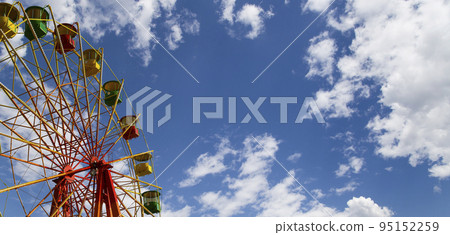 Attraction (carousel) ferris wheel on the background of the cloudy sky Attraction (carousel) ferris wheel on the background of the cloudy sky 95152259