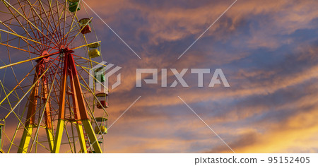Attraction (carousel) ferris wheel against the background of a romantic evening sky Attraction (carousel) ferris wheel against the background of a romantic evening sky 95152405