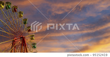 Attraction (carousel) ferris wheel against the background of a romantic evening sky 95152419