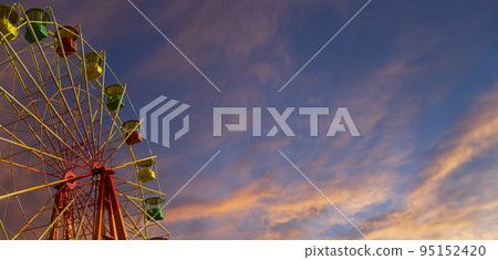 Attraction (carousel) ferris wheel against the background of a romantic evening sky 95152420