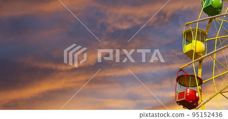 Attraction (carousel) ferris wheel against the background of a romantic evening sky Attraction (carousel) ferris wheel against the background of a romantic evening sky 95152436