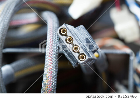 Very dirty wires, connectors and plugs in the computer. Old multi-colored wires in a braided wrapper. Stranded electrical wire in electronic equipment. Service workshop for electronics repair. 95152460