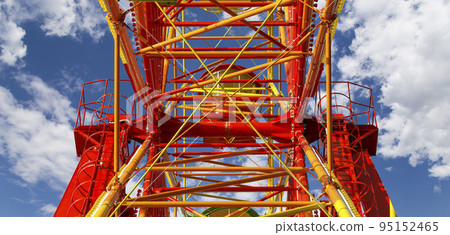 Attraction (carousel) ferris wheel on the background of the cloudy sky Attraction (carousel) ferris wheel on the background of the cloudy sky 95152465