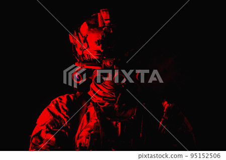 Half length, low key studio shoot of army soldier, marine infantryman in mask, camo uniform, equipped modern ammunition, armed service rifle standing in darkness with night vision device on helmet Half length, low key studio shoot of army soldier, marine infantryman in mask, camo uniform, equipped modern ammunition, armed service rifle standing in darkness with night vision device on helmet 95152506