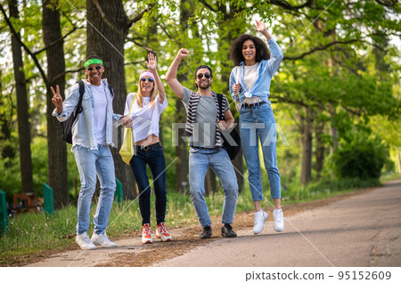 Young tourists hitchhiking on the forest road Young tourists hitchhiking on the forest road 95152609