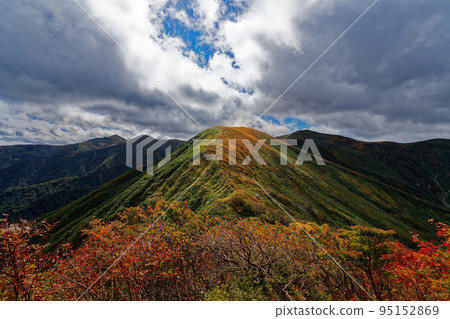 Mt. Yufung with colored leaves illuminated through the clouds 95152869