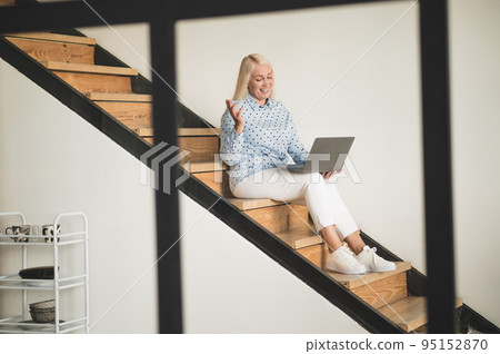 Merry mature woman communicating over the Internet 95152870