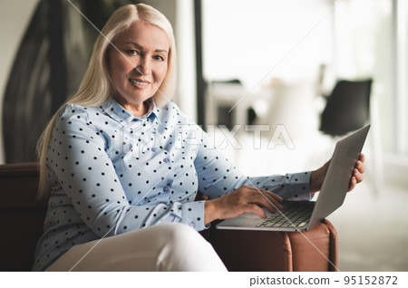 Cheerful lady posing for the camera with her portable computer 95152872