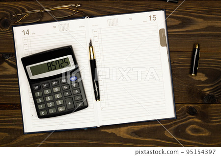Top view office table desk. Financial report. Flat lay. Workspace with Business office supplies, empty sheet of diary, pen, glasses, calculator on the table. Copy space for text. Top view. Close-up Top view office table desk. Financial report. Flat lay. Workspace with Business office supplies, empty sheet of diary, pen, glasses, calculator on the table. Copy space for text. Top view. Close-up 95154397