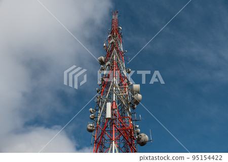 Large transmission tower against deep blue sky and clouds Large transmission tower against deep blue sky and clouds 95154422