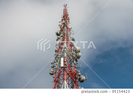 Large transmission tower against deep blue sky and clouds Large transmission tower against deep blue sky and clouds 95154423