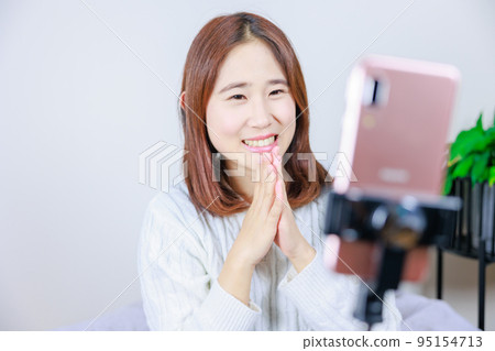 Woman talking on mobile phone using selfie stick 95154713